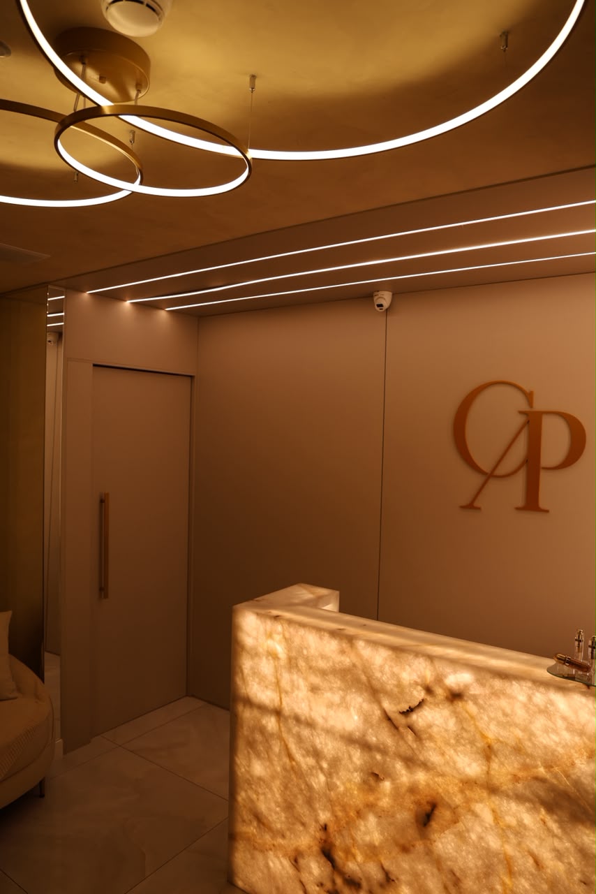 Ambiente da Clínica Piccirillo com lounge e recepção em mármore e dourado